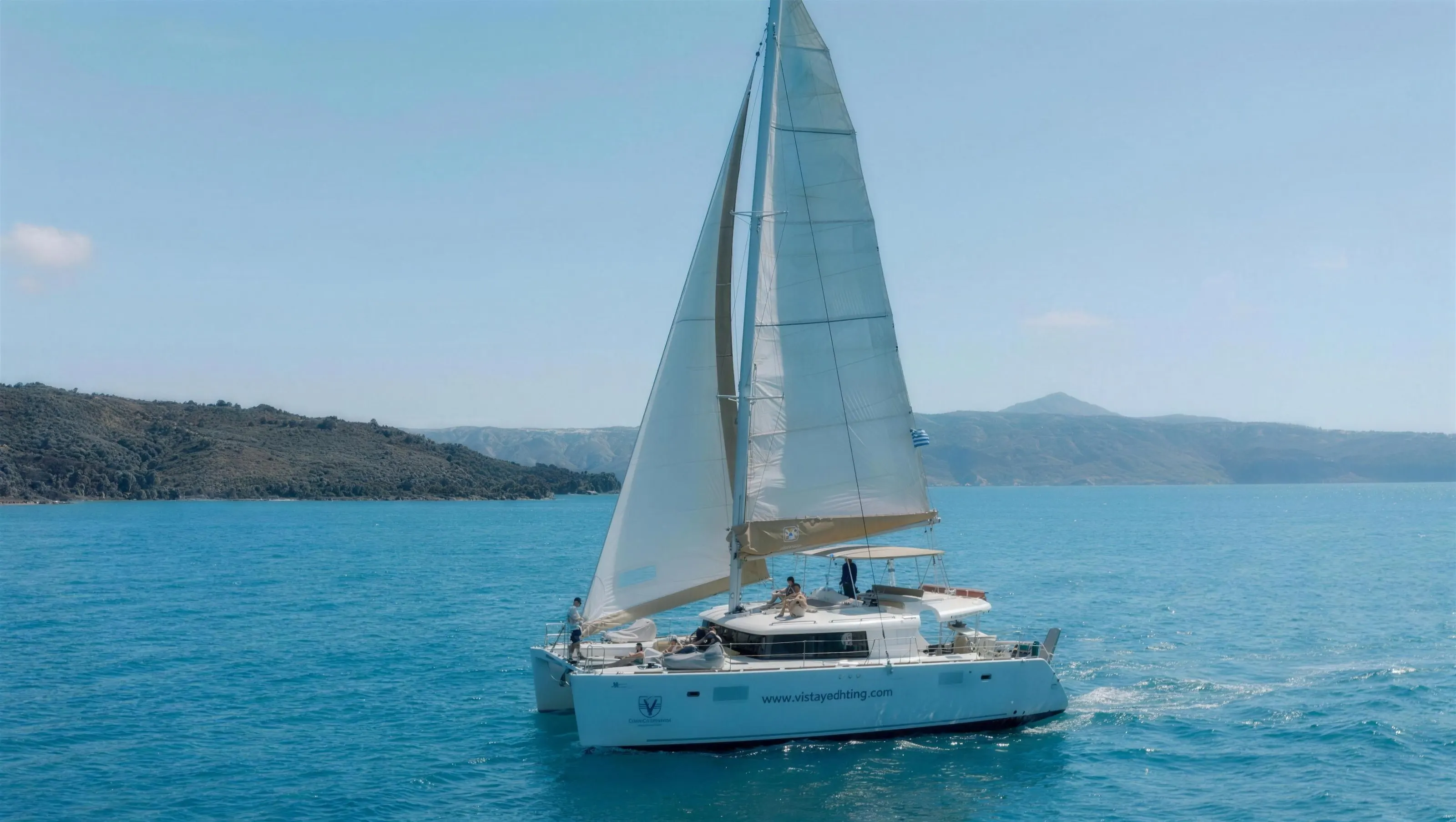 Vista Yachting catamaran under sail in the Santorini caldera on a day cruise