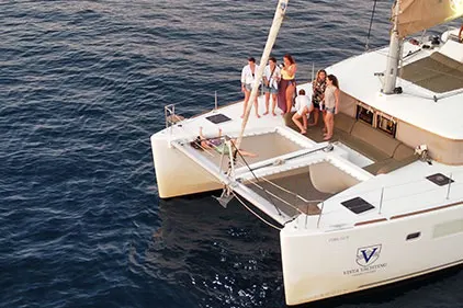 Group selfie on bow at golden hour Santorini sunset cruise