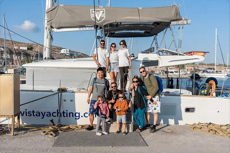 Happy guests posing on the bow nets before boarding for their semi‑private cruise.