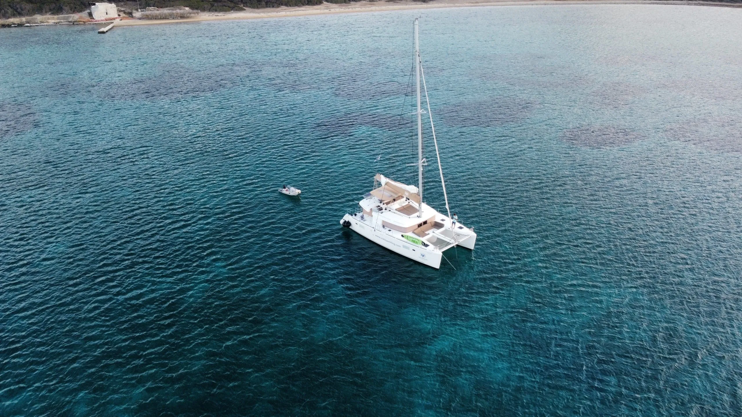 Time Out catamaran anchored in a turquoise bay in the Cyclades
