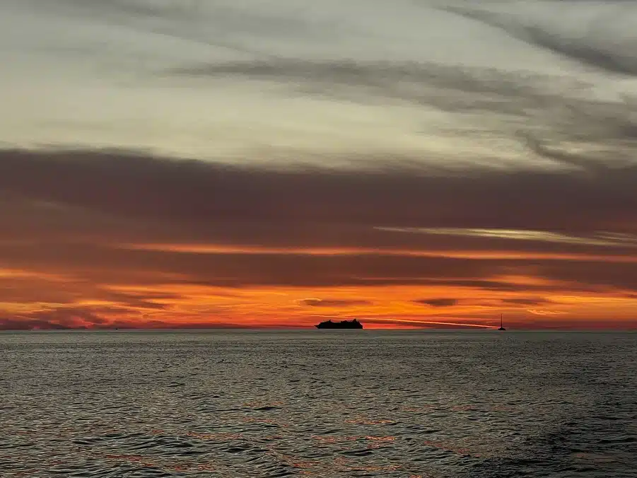 Orange sunset over the sea seen from a boat off Santorini